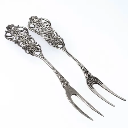 Två serveringsgafflar i silver (830/1000), längd 160 och 165 mm. Stämplade GEWE (Gewe Silvervarufabriken AB, Malmö), Silverstämpel & Kattfot. Vikt: 34,3g.