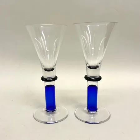 2 glas på fot, höjd 20,5cm, Studio Åhus Sweden 1997, gravyr undertill AWA Patent 100 years, blått/svart klarglas Skickas med paket.