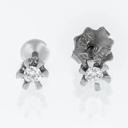 Örhängen, Stjärnringen "Galaxia" i 18K vitguld med 2 x 0,05ct briljantslipade diamanter (Tw/Luppren/vvs). De är 4,2 mm breda och väger 0,9g. Stenstorlek ingraverad på stift. En snurrebuss saknas, men ny i plast medföljer.