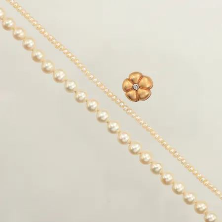 Två pärlcollier med odlade pärlor, Ole Lynggaard, längd ca 43-48cm, bredd ca 3-6,4mm, dobbar i metall, lås i 18K med diamanter ca 2 x 0,01ct, låsets vikt: 5,1g, bruttovikt: 33,74g, originalask, sliten ask