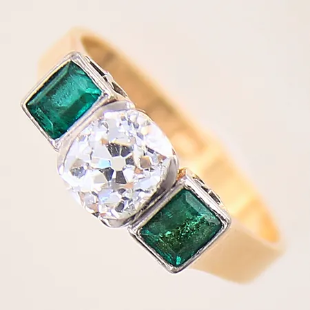 Ring med kuddslipad diamant ca 1,14ct, kvalitet ca W(H)/ VVS, samt smaragder, stl 17, bredd 2,5-6mm, fattning i platina, Thor Lindquists Guldsmedsverkstad, år 1956, smaragder med smärre slitage vid fasetter, diamant med mindre nagg vid ena klon, 18K  Vikt: 4,2 g