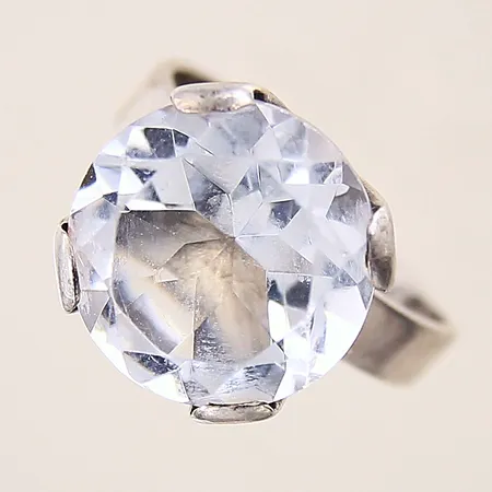 Ring med vit sten, stl 19¾, bredd 4-16mm, skev, repig samt nagg på sten, ställbar skena, silver 925/1000 Vikt: 7,7 g