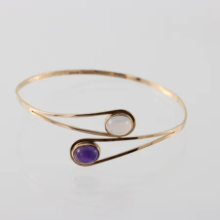 Armring med cabochonslipad vit och lila sten, något ojämn form , Diameter ca 60mm, öppningsbar, Hedbergs Guld- & Boetttverkstad Stockholm 1960, 18k Vikt: 8,9 g
