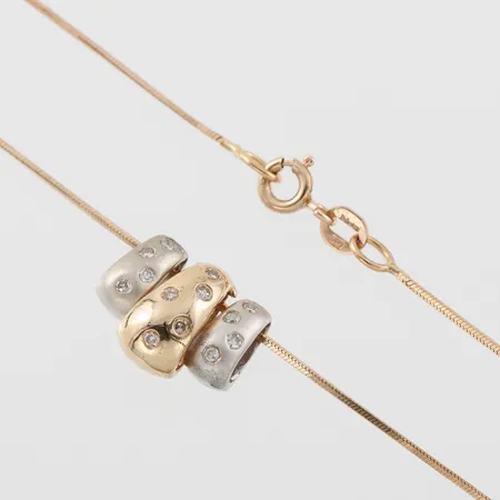 Collier med små diamanter i hängen röd och vitguld , längd ca 41 cm, bredd 0.7-11.2 mm, stämplat SSÄ,18k. Vikt: 6,4 g