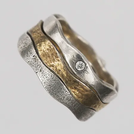 Tre ringar varav en med vit sten, en förgylld, stl: ca 18, bredd tillsammans: 8 mm, 925/1000 silver. Vikt: 9,5 g