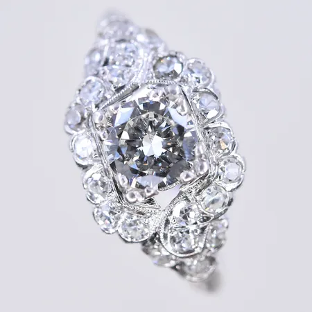 Ring med diamant ca 1x0,65 ctv och 22 st gammalslipade diamanter Top Crystal VS, stl 16½, bredd 2-10 mm, minimal skada på rondisten, Platina 900/1000. Vikt 3,5g.