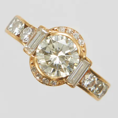 Ring, 1 briljantslipad diamant Ca-TCa/VS2 1,67ctv enligt gravyr, 2 baguetteslipade diamanter 0,37ctv enligt gravyr, 6+8 briljantslipade diamanter 0,84ctv enligt gravyr, Ø17¼, bredd: 3,8-11,3mm, hack på ringskena, Kaplans Safir AB, 1986, 18K Vikt: 7,9 g