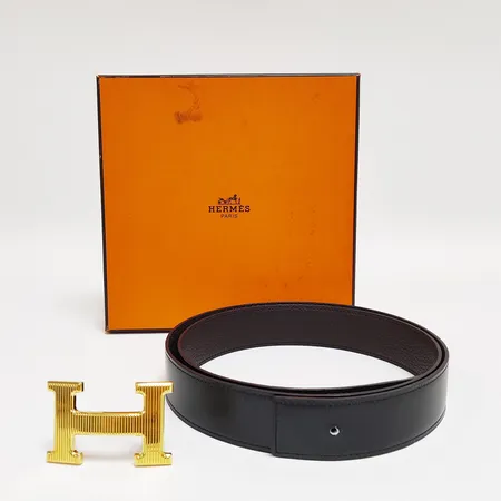Skärp, Hermès, 92-97cm, bredd: 31-38,3mm, svart/brunt läder, märke, spänne i gulmetall, liten missfärging, dustbag, etui med fläckar. 