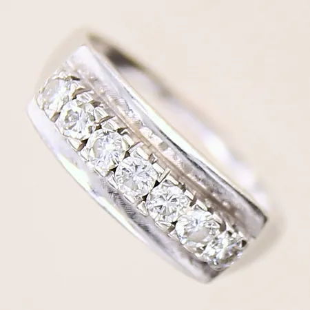 Ring med diamanter 7 x ca 0,06ct, stl: 18, bredd: 1,1-7mm, ostämplad vitmetall 