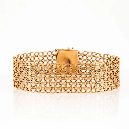 Armband, x-länk i 18K guld. Det är 20 cm långt, 19,5 mm brett och väger 30,0g. Kistlås. Stämplad NSE (NSE Guldvaru AB, Köping), A10 (1975), 18K & kattfot. 