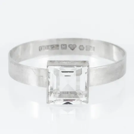 Armring i silver med stor bergkristall. Storlek c:a Ø 52 x 60,5 mm. Den är 10 - 20 mm bred. Bruttovikt: 30,7g. Stämplad GD&Co (Guldvaruaktiebolaget G. Dahlgren & Co Ab 	 Malmö), T9 (1969), Silver & Kattfot. 