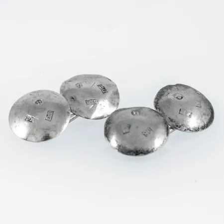Manschettknappar i silver, c.a 14 x 14 mm. Väger 3,6g. Stämplad. ELR (Erik Erson Linderoth, Umeå), B6 (1880) & JH (Johan Hanson) lärling hos Erik Erson Linderoth, D6 (1882). Ojämnheter.