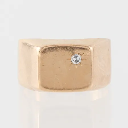 Klackring med liten diamant, ojämnheter, storlek 18 ½ mm, bredd 6-11.3 mm, 18k. Vikt: 6,5 g