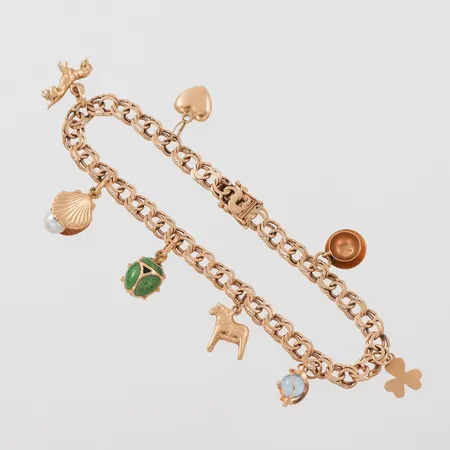 Armband med 8 st berlocker, längd ca 19.5 cm, bredd 5.3 mm, 18k. Vikt: 16,5 g