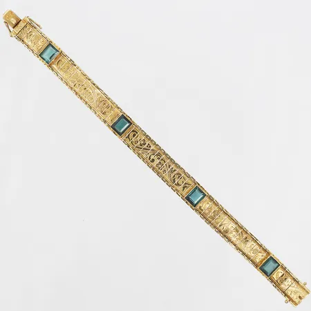 Armband med gröna syntetiska spineller samt blomsterdekor, längd 18½cm, bredd 10mm, svenska importstämplar, 18K guld Vikt: 18,2 g