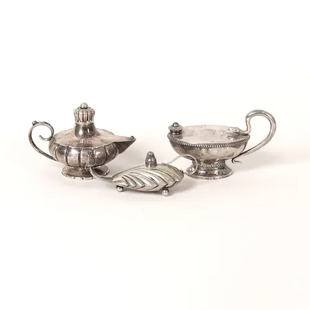 Tre oljelampor, höjd 6,5-3,5cm, olika modeller, bland annat CG Hallberg, Stockholm, 1920, slitage, två saknar lockknopp, silver.  Vikt: 210,8 g