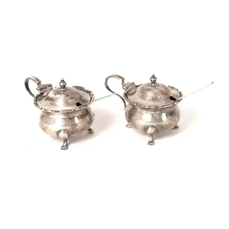 Ett par saltkar, Adie Brothers Ltd, Birmingham, England, 1900-talets första hälft, höjd 5cm, med lös glasinsats, silvervikt 85g, slitage, insatser med nagg, saltskedar av metall medföljer.    