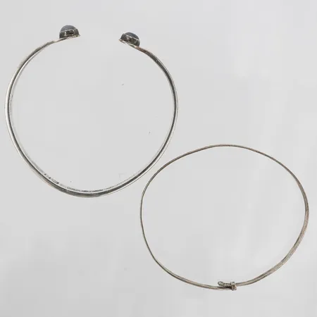 Två armringar, varav den ena med vita stenar samt signerad EH, Gävle, 1961, den andra med graverad dekor, innermått ca Ø66x60mm, 64x60mm respektive 64x55mm, båda med slitage och bucklor, silver.   Vikt: 30,3 g