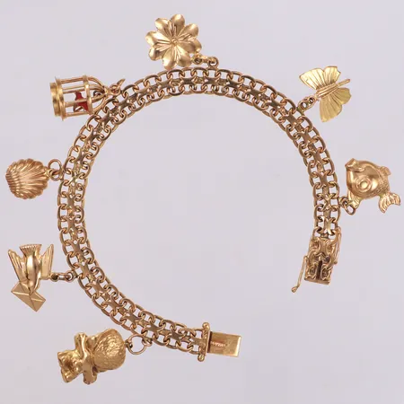 Armband X-länk med sju berlocker, G. Dahlgren & Co år 1961, längd 18,5cm, bredd 7,0mm, 18K Vikt: 20,5 g