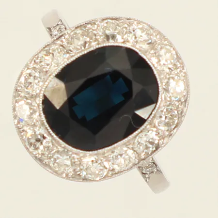 Ring med safir samt diamanter 14x ca 0,05ct, stl 16¾, bredd ca 1,5-16mm, otydlig stämpel, troligen Platina  Vikt: 4,8 g