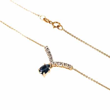 Collier i 18K guld med 11 diamanter á c:a 0,005ct och en droppslipad safir.  Den har ställbar längd 44 / 49,5 cm, är 0,6 mm bred och väger 2,4g. Det fasta mittpartiet är 17,5 mm brett. Springring. Stämplad GHA 750. 