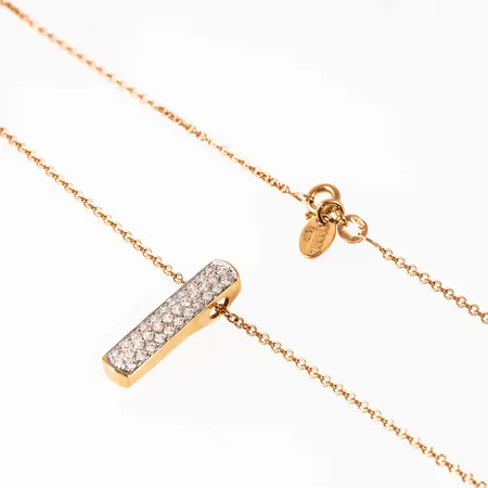 SCOOP: kedja och berlock med vita stenar i 18K guld. Kedjan är 40,5 cm lång, 0,95 mm bred och har springring. Berlocken är 23,2 x 5,3 mm och går att ta av. De väger 4,8g tillsammans. 