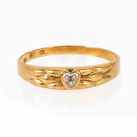 Ring i 18K guld med en åttkantslipad diamant c:a 0,005ct fattad i hjärta. Den är 1,8 - 4,3 mm bred, är i storlek 18¼ och väger 1,3g. HSG, 18K & Kattfot.