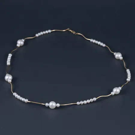 Collier i 18K guld med sötvattensodlade pärlor i olika storlekar. Det är 1,2 - 8 mm brett, 44 cm långt, och väger 7,7g inklusive pärlor. Stämplad GHA, 750. Framstår oanvänd.