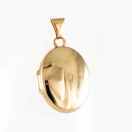 Medaljong i 18K guld. Den är oval 14 x 17 mm och väger 1,4g. Stämplad HSG, 750 & Kattfot. Svag buckla.