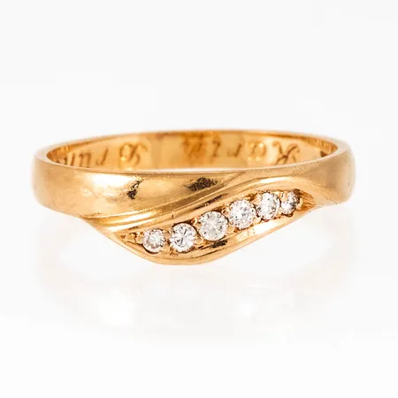 Ring i 18K guld med 4 x c:a 0,02ct och 2 x c:a 0,01ct briljantslipade diamanter fattade i "överlapp". Den är i storlek 17½, är 2,4 - 5,4 mm bred och väger 2,8g. Stämplad HE (Heribert Engelbert, Stockholm), X10 (1996), 18K & Kattfot. Gravyr. 