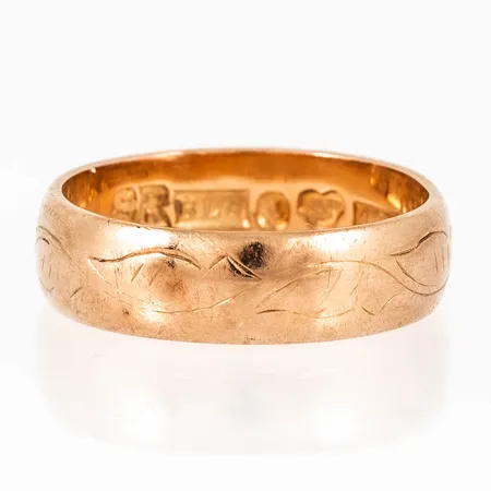 Ring i 18K guld med handgraverat lövmönster. Den är i storlek 17¾ , är 5,5 mm bred och väger 5,2g. Stämplad S9 (1968), BLG (Bertil Lundberg Guldsmedsatelje AB, Stockholm), 18K & Kattfot.