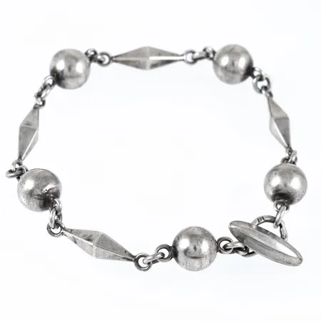 Armband i silver med kulor. Det är 21 cm långt, 4,5 - 9,5 mm brett och väger 18,5g. Stämplad R9 (1967), AMS (Arvo Saarela, Enköping), Silverstämpel & Kattfot.