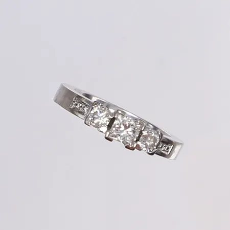Ring med diamanter 1x prinsesslipad 0,40ct TW/VS, 2x 0,17ct W/VS enl. gravyr samt 4x ca 0,005ct, stl 16¼, bredd 3-5mm, tjocklek 2-5mm, tillv. JSS (Jarl Sandin Göteborg), vitguld 18K Vikt: 6,1 g