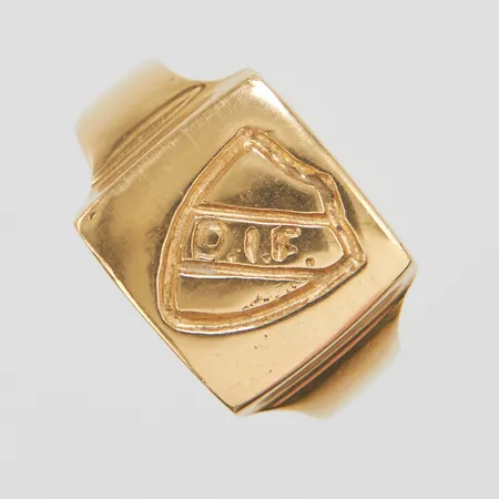 Klackring med emblem, Ø19, bredd: 3,8-12,8mm, skev, sprickor i klacken, ostämplad, 18K Vikt: 6,7 g