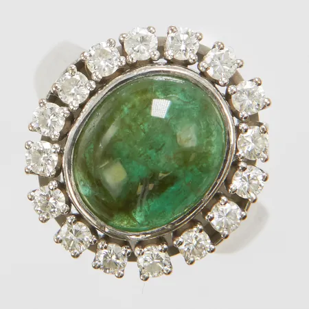 Karmoséring med en cabochonslipad smaragd 5,70ct enligt gravyr, 16 diamanter 0,84ctv enligt gravyr, Ø17½, bredd: 3,1-18,3mm, smaragden har en del nagg, Ceson, Göteborg, 1986, vitguld, 18K Vikt: 11,5 g