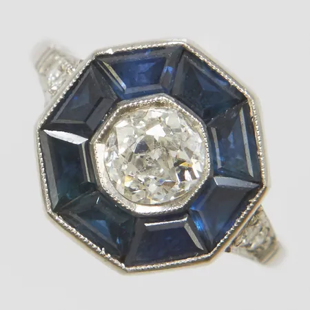 Ring med en gammalslipad diamant ca.0,65ct, ca.Cr(J)/P1, safirer samt äldre slipade diamanter 1 x ca.0,03ct, 1 x ca.0,025ct och 2 x ca.0,02ct, Ø16¼, bredd: 1,6-12,6mm, ostämplad, platina