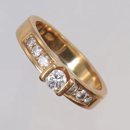Ring med diamanter 1xca0,25ct samt 6xca0,02-0,05ct (totalt 0,59ct enl gravyr) stl 18½ bredd 4mm, något skev (oval form),  JPJ (Jannerberg Guldsmide) Göteborg 18K Vikt: 7,3 g