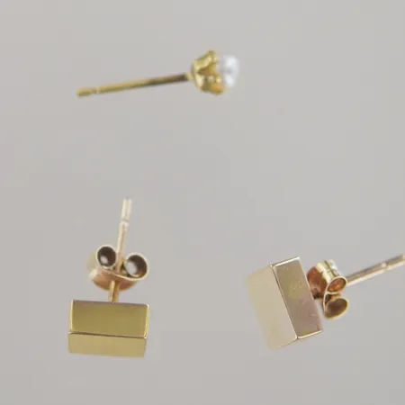 Örhängen 2st olika. Ett par, höjd 14mm bredd 0,6mm. Ett singelörhänge med pärla  höjd 14mm plopp saknas, 18k  Vikt: 1,6 g