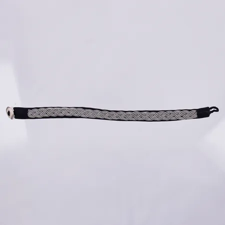 Armband i läder, Sameslöjd, med flätad tenndekor, knapp i horn, längd 19 cm, bredd 10 mm