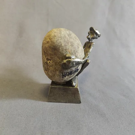 Skulptur, Lyftet, Henry Gustafsson, höjd ca 8,5cm inklusive sockel, sten och tenn, signerad, synliga limrester, lös sten