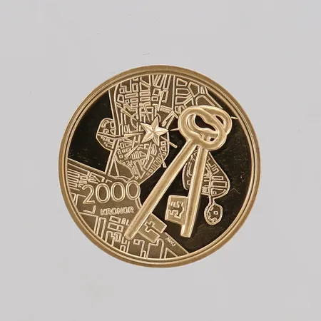 Jubileumsmynt, Stockholms Slott 250 år, 2004, ca Ø21mm, 21,6K guld, etui.  Vikt: 12 g