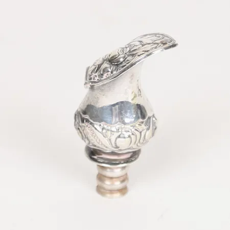 Flaskpip med organisk dekor, höjd: 71 mm, bredd: ca 40 mm, nedre mynning Ø13 mm, saknar stämplar, slitage, silver. Vikt: 28,7 g