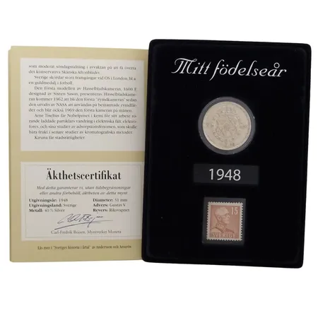 Minne 1948 - "Mitt födelseår", innehåller 2 Krona i silver 40% + Frimärke 15 Öre, smakfull montering, mått 14x10 cm, inramning med stödben, informationshäfte medföljer, fint skick