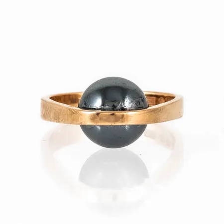 Ring i 18K guld med hematitkula. Den är i storlek 18¼, är 3,5 - 10 mm bred och väger 7,2g. Stämplad A11 (1999), ALTON, Falköping, 18K & Kattfot. 