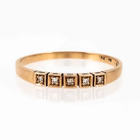 Ring i 18K guld med 5 x c:a 0,01ct åttkantslipade diamanter i carréfattning. Den är i storlek 20, är 1,5 - 2,7 mm bred och väger 1,7g. Stämplad 18K & Kattfot.