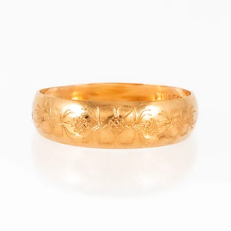 Doserad ring i 18K guld med graverat blomstermönster. Den är i storlek 15½, är 2,5 - 5 mm bred och väger 0,8g. Stämplad VJ (Viktor Janson) & 18K.