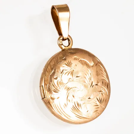 Hänge i 18K guld: Medaljong med mönstergravyr. Den är Ø 18 mm och väger 3,7g. Stämplad 18K & Svensk importstämpel.