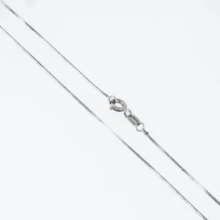 Kedja, kantig ormlänk i 18K vitguld. Den är 47,5 cm lång, 0,7 mm bred och 2,3g. Stämplad GHA & 750. Springring. Ojämnheter.