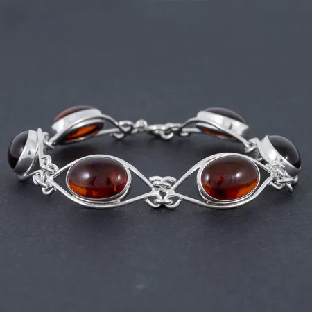 Armband i silver (925/1000) med bärnsten. Det är 18 cm långt, är 7,2 - 12,4 mm brett och väger 12,9g. 