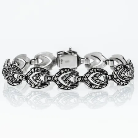 Armband i silver (830/1000) med markasiter. Det är 18 cm långt,  3,3 - 11,5 mm brett och väger 17,4g. Kistlås. Silver & Svensk importstämpel. Saknar en sten. Två stenar skadade.